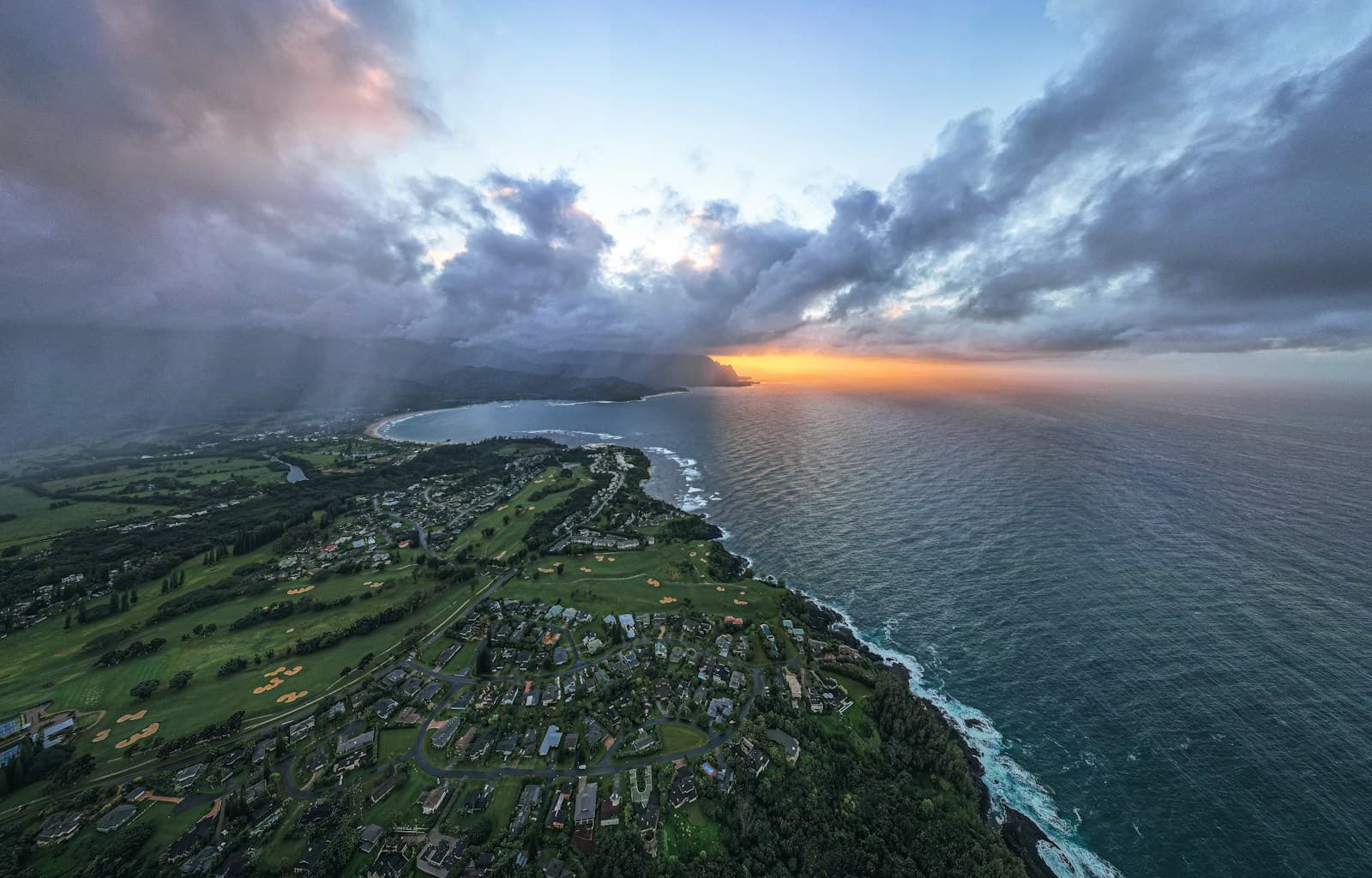 Sanft hügelige Golf-Fairways am Meer im weichen Licht des Sonnenuntergangs